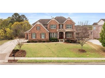 Stately brick home boasts a manicured front lawn and symmetrical landscaping, creating a welcoming curb appeal at 260 Millstone Pkwy, Woodstock, GA 30188