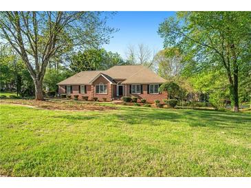Charming brick home with a lush green lawn and mature trees, offering a welcoming curb appeal at 2025 Golden Ridge Cir, Cumming, GA 30040