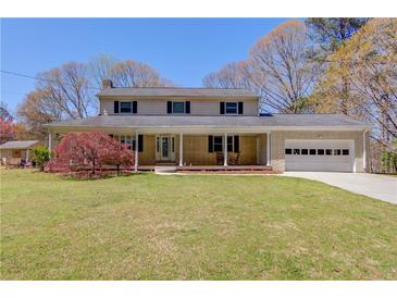 Inviting two-story home with a covered front porch, attached garage, and well-manicured lawn at 692 W Union Grove Cir, Auburn, GA 30011