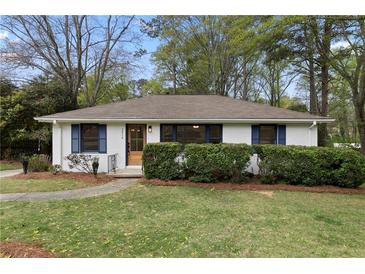 Charming home featuring a lush green lawn, inviting curb appeal and a freshly painted exterior at 3216 Woodview Se Dr, Smyrna, GA 30082