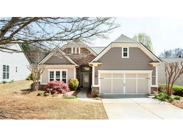 Charming single-story home with stone accents, a well-manicured lawn, and a two-car garage at 4520 Vanadium Bnd, Cumming, GA 30040