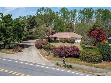 Charming single-story home with mature landscaping and a long driveway at 660 Hembree Rd, Roswell, GA 30076