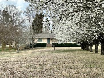 Charming home featuring a sprawling front yard and mature trees, creating a serene setting at 5791 Warren Farm Sw Rd, Powder Springs, GA 30127