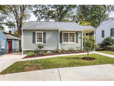 Charming one-story home featuring gray siding, updated windows, a manicured lawn, and a sidewalk at 1257 Lyle Pl, Atlanta, GA 30318