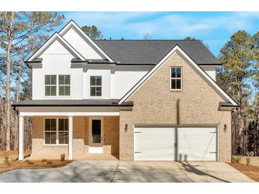 Charming two-story home featuring a brick facade, white siding, and a two-car garage at 4444 Sullivan Rd, Powder Springs, GA 30127