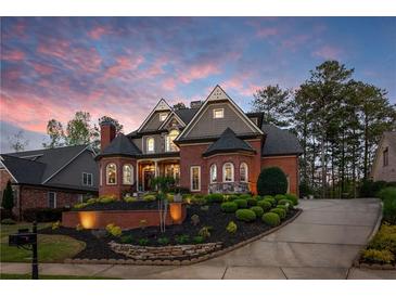 Stunning brick home with manicured landscaping and a circular driveway at dusk at 145 Cuthbert Ln, Acworth, GA 30101