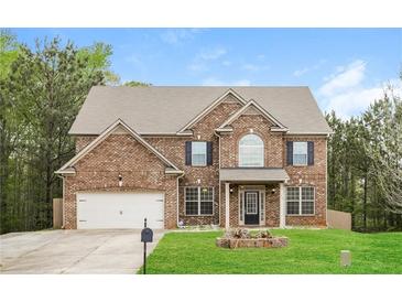 Charming two-story brick home featuring a well-manicured lawn and an attached two-car garage at 245 Astoria Way, Mcdonough, GA 30253
