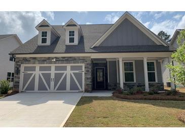 Charming home featuring a stone and gray plank facade, dormer windows, and a two-car garage at 122 Airmont Dr, Sharpsburg, GA 30277