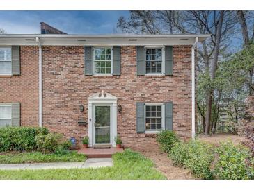 Charming brick home with well-manicured landscaping, front door with sidelights and decorative shutters at 1674 Executive Park Ne Ln, Atlanta, GA 30329
