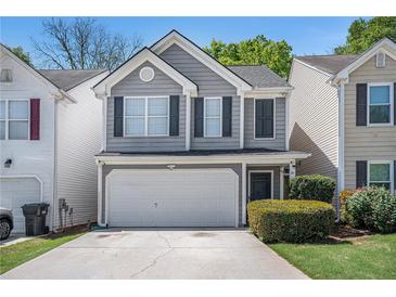 Charming home with a two-car garage, gray siding, black shutters, and well-maintained landscaping at 30 Crestfield Cir, Covington, GA 30016
