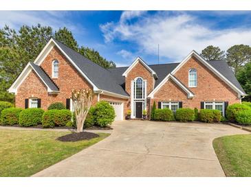 Charming brick home with lush landscaping, black shutters, and a well-manicured lawn at 3541 Haddon Hall Dr, Buford, GA 30519