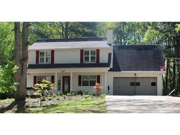 Charming two-story home featuring red shutters, a well-manicured lawn, and an attached two-car garage at 4314 Saddlecreek Ct, Auburn, GA 30011
