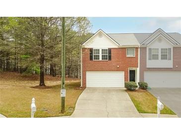 Charming brick townhome featuring an attached garage, driveway, and neatly maintained landscaping at 809 Brickleridge Se Ln, Mableton, GA 30126