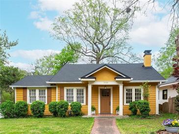 Charming yellow bungalow-style home with a well-maintained front yard and inviting brick pathway at 2129 Fairhaven Ne Cir, Atlanta, GA 30305