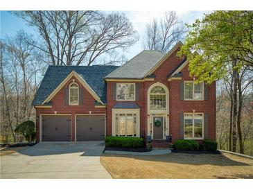 Charming two-story brick home with a well-manicured lawn and a two-car garage at 2275 Barrett Dr, Cumming, GA 30040
