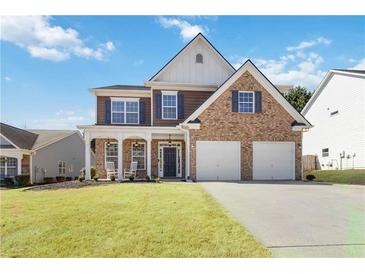 Charming two-story home with brick and siding, inviting front porch, and a two-car garage at 416 Pine Log Ct, Canton, GA 30115