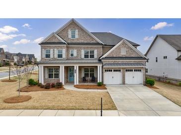 Charming two-story brick home featuring a welcoming front porch, two-car garage, and beautifully landscaped front yard at 4405 Croftshire Pl, Cumming, GA 30040
