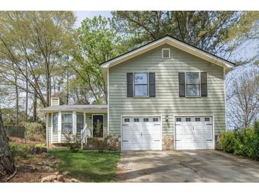 Charming exterior view featuring a well-maintained lawn and a two-car garage at 4520 Jackybell Trl, Decatur, GA 30034