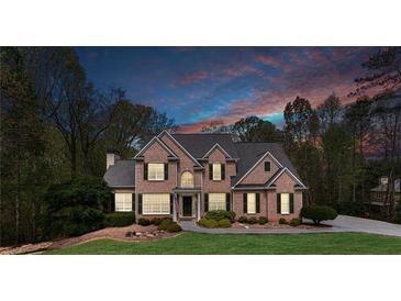 Stunning brick home featuring manicured lawn, tasteful landscaping, and a grand entrance at 2830 Willow Hill Ct, Cumming, GA 30040