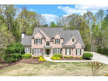 Charming brick home with manicured lawn, lush landscaping, and a welcoming entrance at 2830 Willow Hill Ct, Cumming, GA 30040