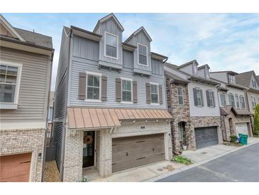Charming townhome showcasing craftsman details, gray siding, brick accents, and a welcoming two-car garage at 433 Cranleigh Se Rdg, Smyrna, GA 30080