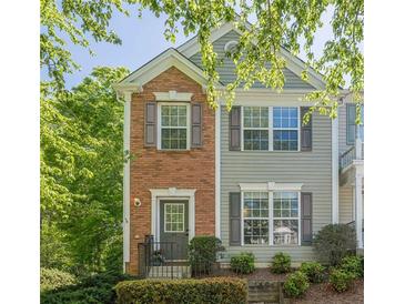 Charming two-story townhouse with brick accents, gray siding, and well-maintained landscaping at 9155 Nesbit Ferry Rd # 65, Alpharetta, GA 30022