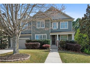 Charming two-story home featuring a well-maintained lawn and beautiful landscaping in a suburban neighborhood at 997 Woodbury Rd, Canton, GA 30114
