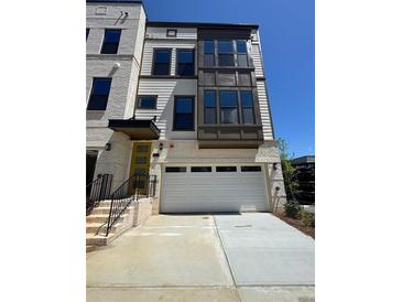 Charming three-story home with a two-car garage and brick and siding facade at 1105 Rivard Nw Cir, Atlanta, GA 30318