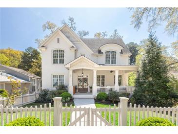 Charming white two-story home with landscaped yard, inviting front porch, and white picket fence at 2877 Elliott Ne Cir, Atlanta, GA 30305