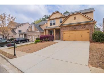 Two-story home with stone accents, two-car garage, driveway, and manicured landscaping at 1498 Scenic Pines Dr, Lawrenceville, GA 30044