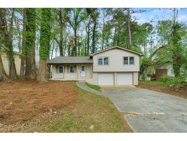 Charming home features a front yard with mature trees and a two-car garage, offering both curb appeal and functionality at 3309 Poplar Dr, Lawrenceville, GA 30044