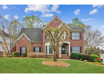 Charming two-story brick home with a well-manicured lawn and mature landscaping at 4155 Summit Gate Dr, Suwanee, GA 30024