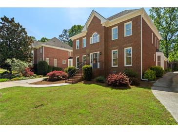 Charming two-story brick home featuring a well-maintained lawn and mature landscaping at 2849 Livsey Woods Dr, Tucker, GA 30084