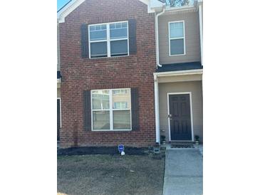 Charming townhouse featuring brick facade and neutral siding with a small front lawn area at 6311 Olmadison Pl, Atlanta, GA 30349