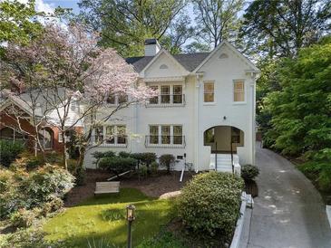 Charming white brick home with blooming tree, bench, and inviting curb appeal at 1503 Emory Ne Rd, Atlanta, GA 30306