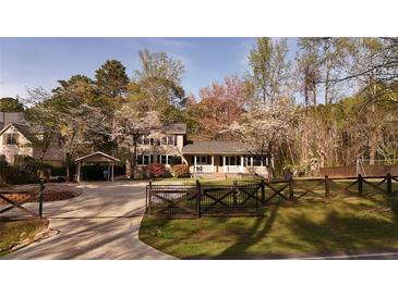 Charming two-story home featuring a covered carport, fenced yard, and a welcoming front porch at 1718 Pucketts Sw Dr, Lilburn, GA 30047