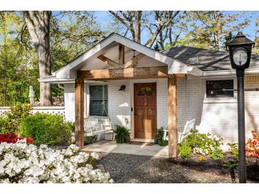 Charming brick home with a welcoming front porch featuring a swing and well-manicured landscaping at 2322 Poplar Springs Ne Dr, Brookhaven, GA 30319