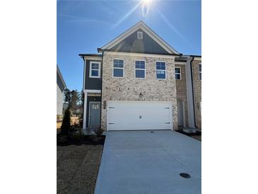 Charming two-story home with brick and siding, showcasing a well-manicured front yard and attached garage at 5607 Hislop Ln # 80, Mableton, GA 30126