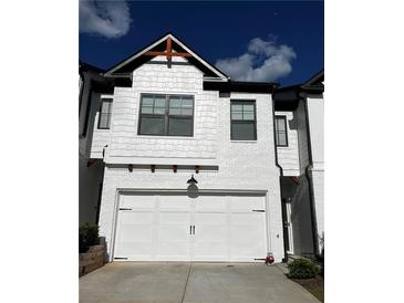 Stylish white two-car garage with black hardware and a complementary exterior design creates a welcoming home entrance at 61 N Auburn Landing Pl, Auburn, GA 30011