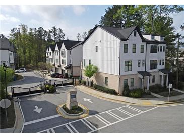 Beautiful exterior view of new townhomes with manicured landscaping and a community gate at 1494 Addison Pl, Decatur, GA 30033