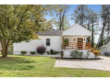 Charming home featuring a front porch and fresh exterior paint, complemented by a well-manicured lawn and mature trees at 2007 Glenwood Se Ave, Atlanta, GA 30316