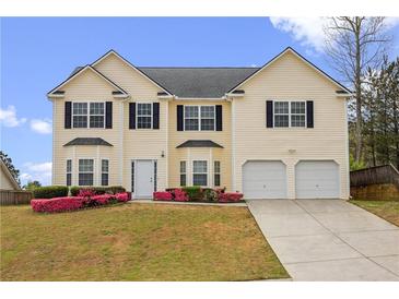 Traditional home featuring two-car garage, neutral siding, and well-maintained landscaping at 210 Millpond Pkwy, Villa Rica, GA 30180