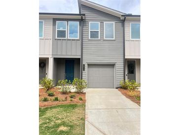 Modern townhome with a gray exterior, manicured landscaping, and a one-car garage at 1516 Parks Edge Nw Ln, Atlanta, GA 30318