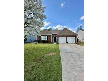 Charming single-story brick home with a well-manicured lawn and two-car garage at 2895 Dominion Walk Ln, Snellville, GA 30078