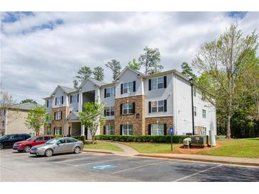 Apartment building exterior with a parking lot and manicured landscaping in a residential neighborhood at 10104 Fairington Ridge Cir, Lithonia, GA 30038
