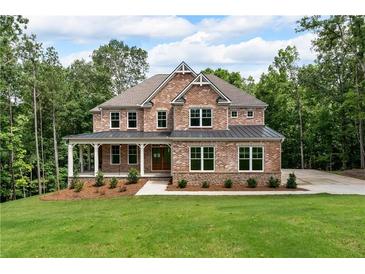 Beautiful two-story brick home with a welcoming front porch and a well-manicured lawn surrounded by lush trees at 7580 Sunridge Ln, Douglasville, GA 30135