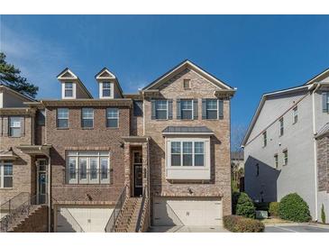 Beautiful brick townhome with two-car garage, covered entry, and multiple windows at 1384 Doublegate Dr, Brookhaven, GA 30319