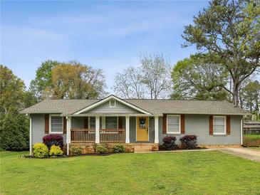 Charming single story home with a covered front porch and mature trees on a well-manicured lawn at 1865 Lochlomand Se Ln, Smyrna, GA 30080