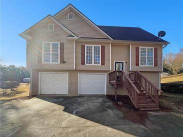 Two-story home with beige siding, a dark roof, and a two-car garage offers classic suburban charm at 46 Norman Rd, Covington, GA 30014