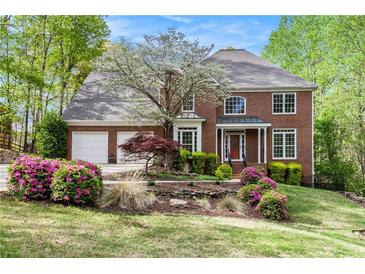Charming brick two-story home with manicured front yard and mature landscaping at 5145 Southlake Dr, Alpharetta, GA 30005